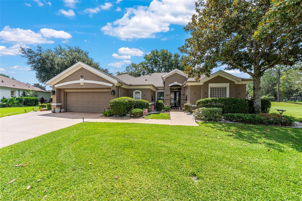 12895 Southeast 91st Terrace Road Summerfield, FL 34491 - Photo 4 of 99 a front view of a house with a garden and yard