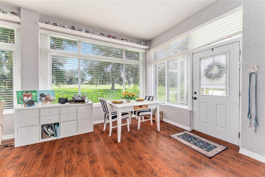 12895 Southeast 91st Terrace Road Summerfield, FL 34491 - Photo 59 of 99 a dining room with wooden floor and a floor to ceiling window