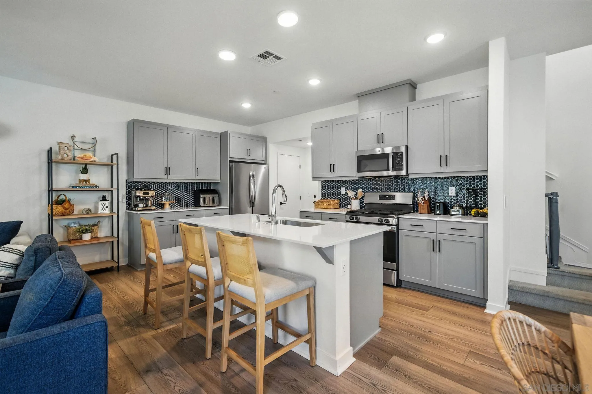 239 Blended Place Fallbrook, CA 92028 - Photo 11 of 64 a kitchen with stainless steel appliances granite countertop a stove a sink a refrigerator and white cabinets with wooden floor