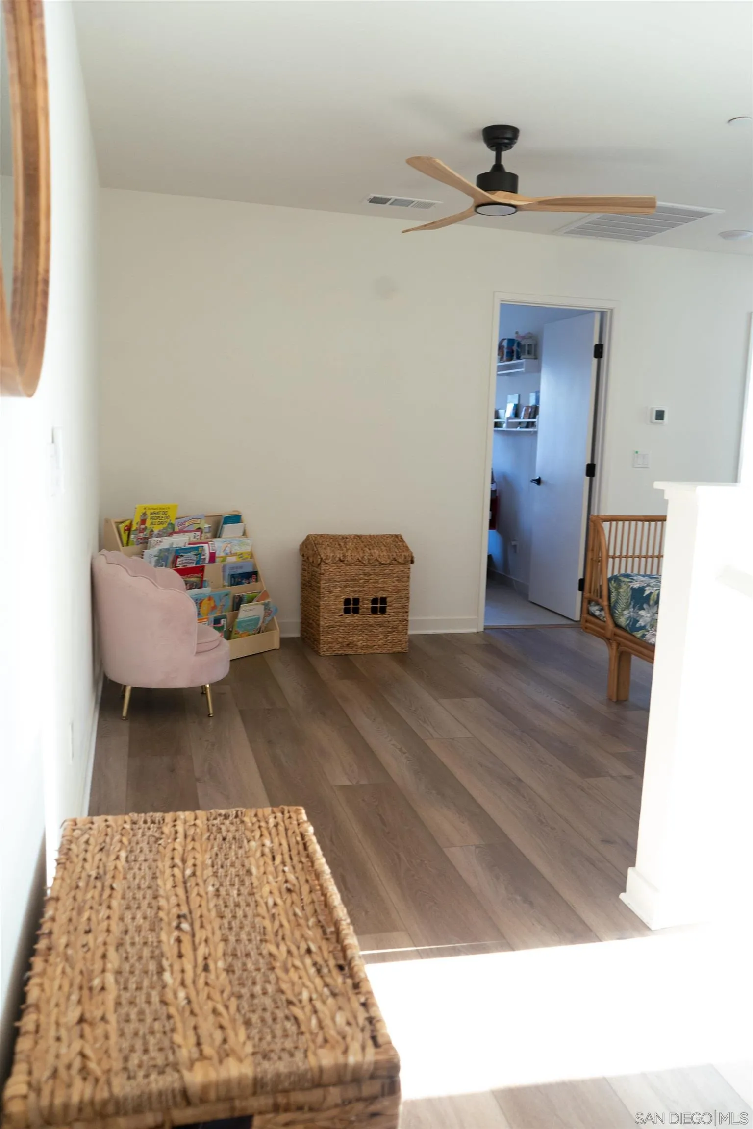239 Blended Place Fallbrook, CA 92028 - Photo 26 of 64 a living room with a baby crib furniture and a wooden floor
