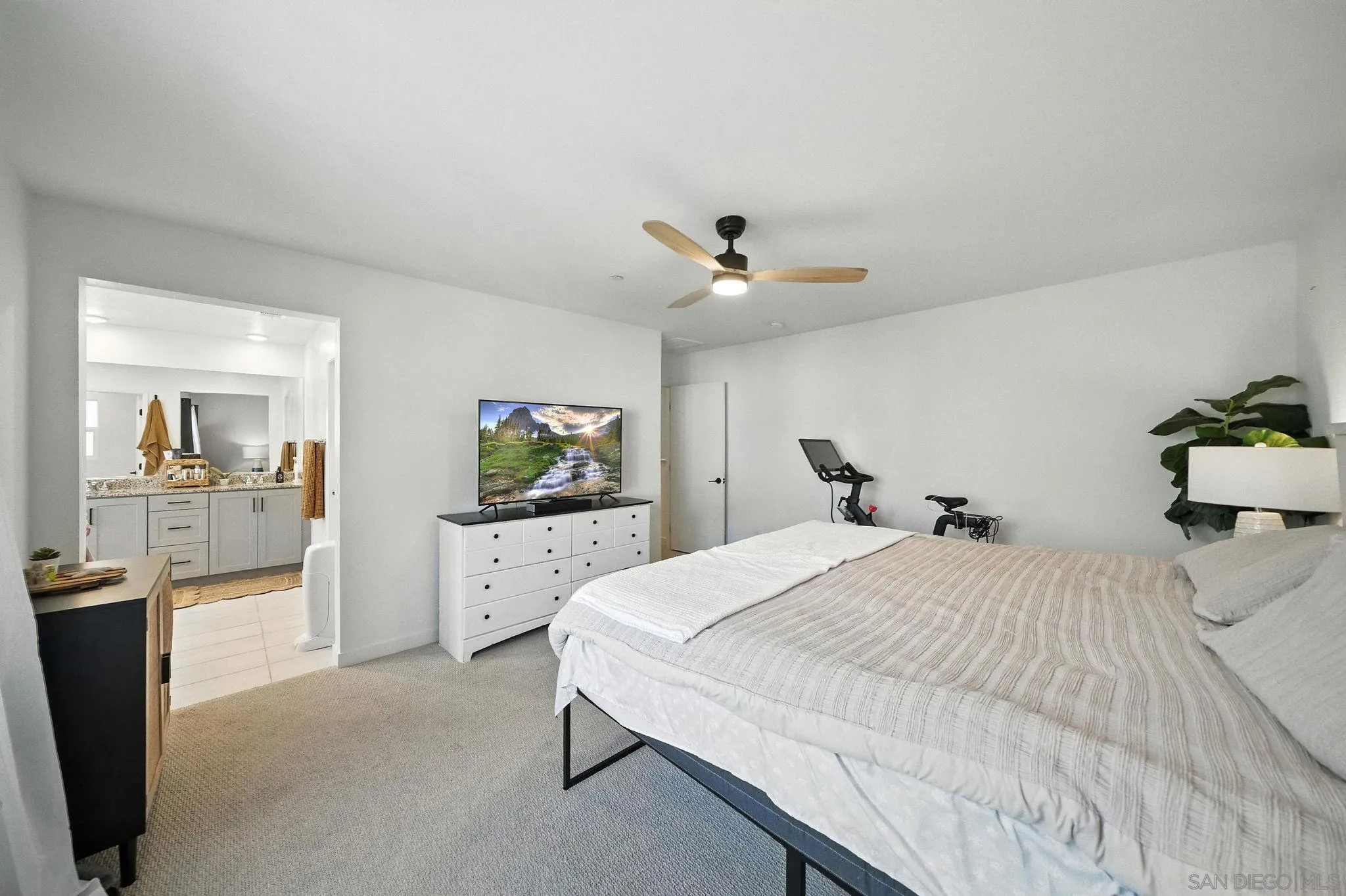 239 Blended Place Fallbrook, CA 92028 - Photo 36 of 64 a spacious bedroom with a bed and a chandelier