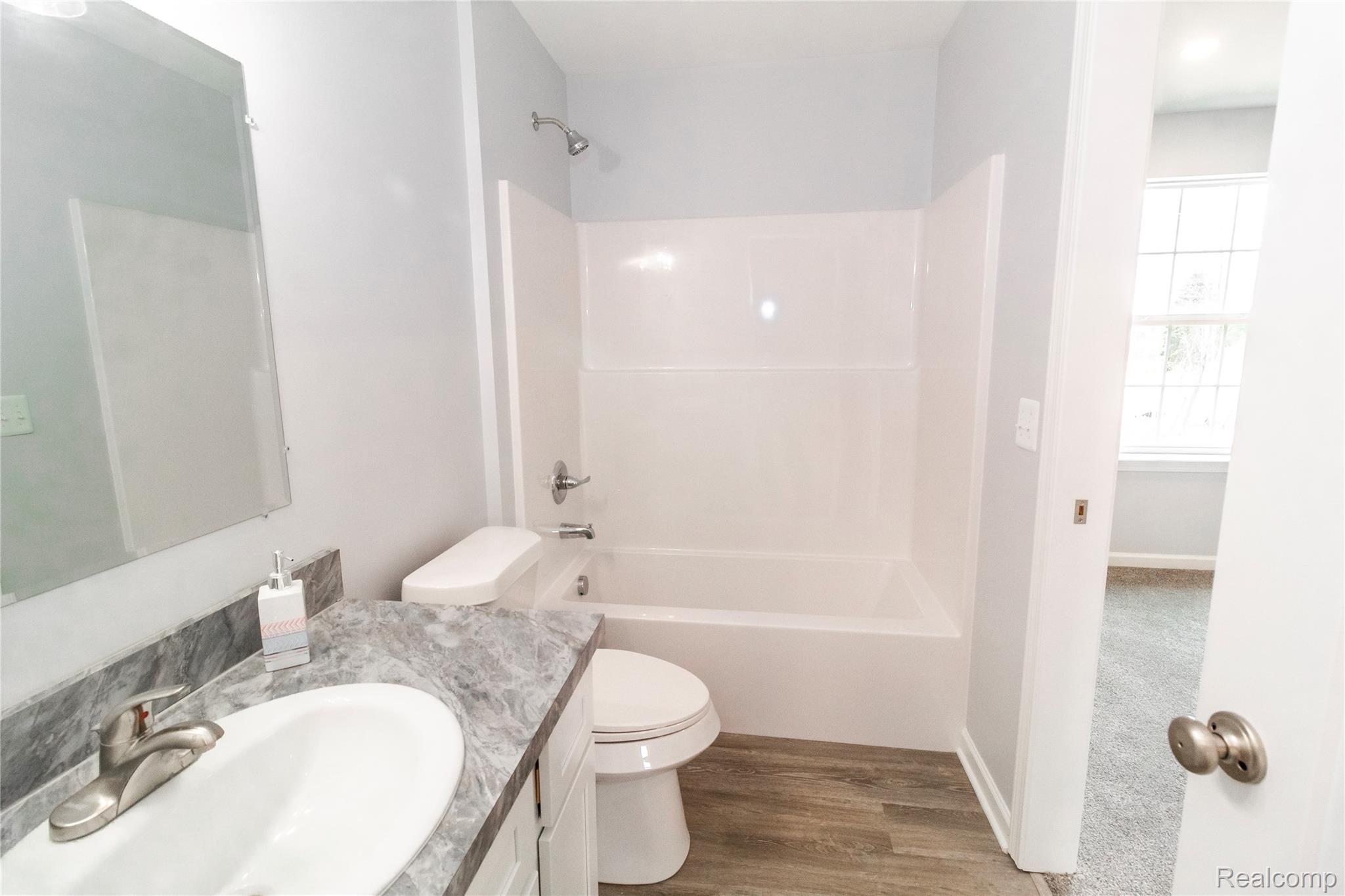 5155 Coldwater Road Lapeer, MI 48446 - Photo 11 of 24 Full bathroom featuring vanity, shower / bath combination, and wood finished floors