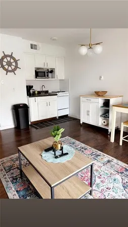 a living room with kitchen island furniture and wooden floor