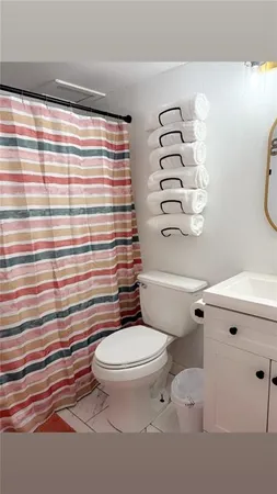 a white toilet sitting next to a shower curtain