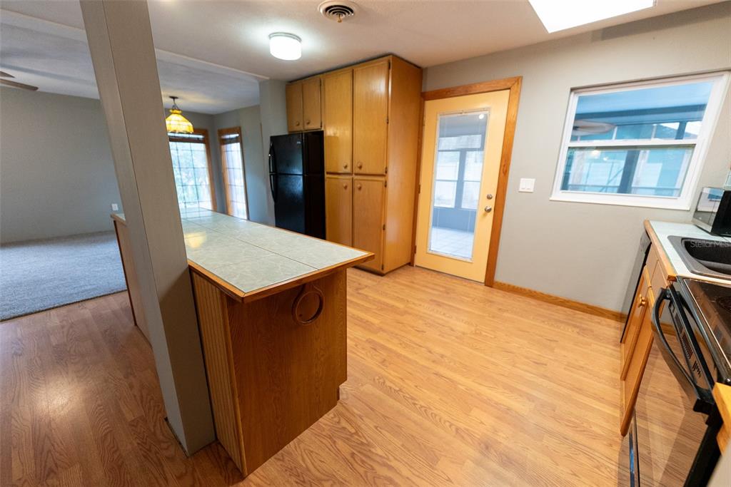 1860 Northeast 62nd Street Ocala, FL 34479 - Photo 16 of 64 a view of kitchen with refrigerator cabinets and wooden floor