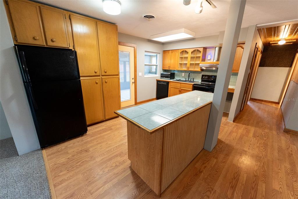 1860 Northeast 62nd Street Ocala, FL 34479 - Photo 10 of 64 a kitchen with refrigerator and wooden floor