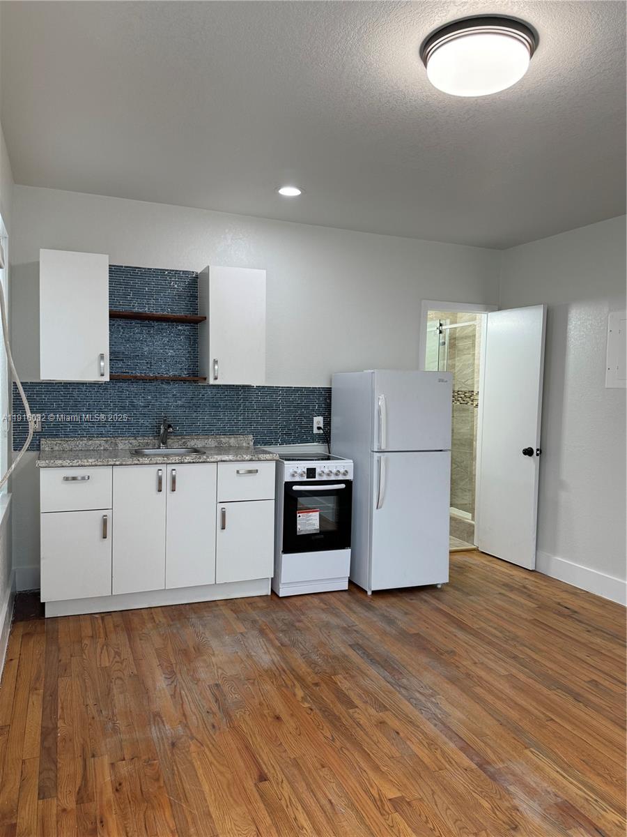 a kitchen with granite countertop a stove and a refrigerator