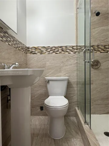 a bathroom with a toilet and a shower