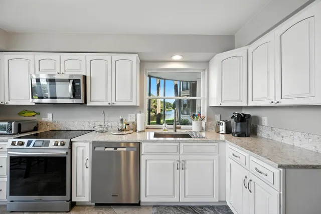 a kitchen with white cabinets stainless steel appliances and sink