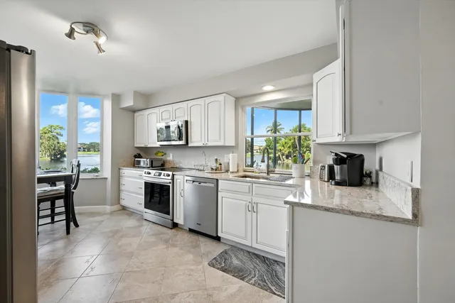 a kitchen with granite countertop white cabinets and white appliances