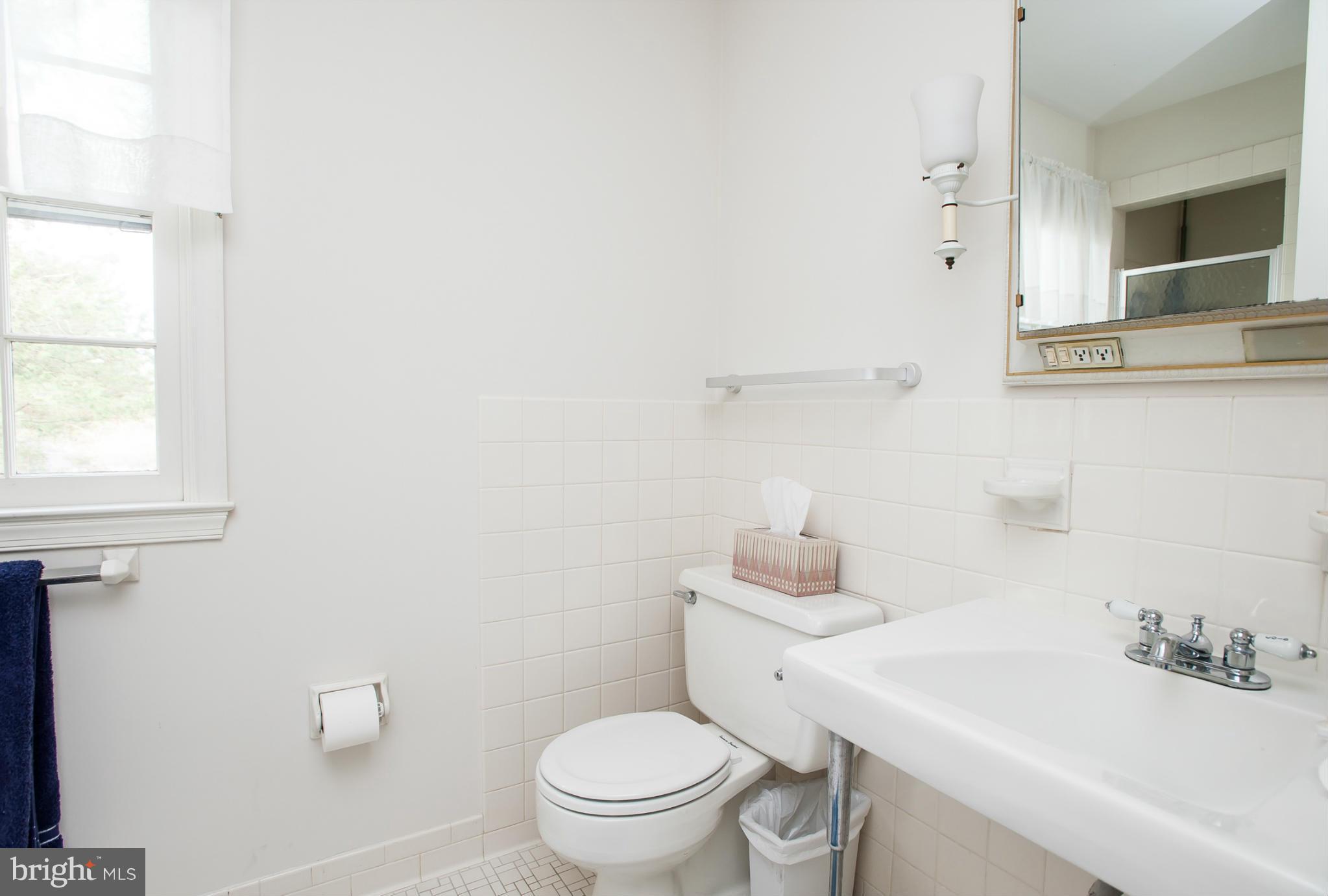 5918 Charlesmead Road Baltimore, MD 21212 - Photo 17 of 27 a bathroom with a sink a toilet and mirror