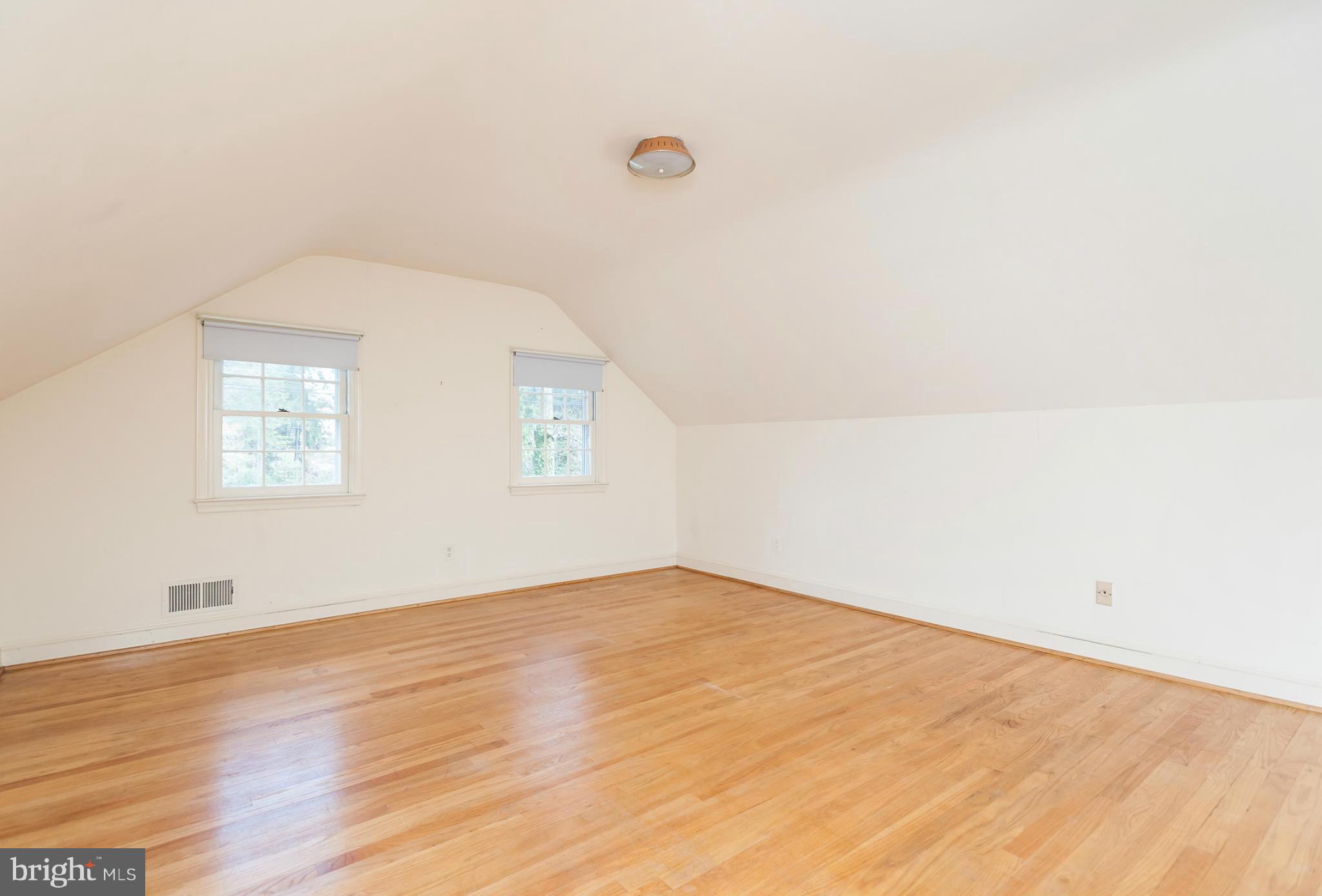 5918 Charlesmead Road Baltimore, MD 21212 - Photo 22 of 27 an empty room with wooden floor and windows