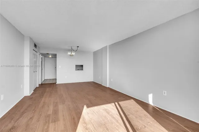 a view of an empty room and wooden floor