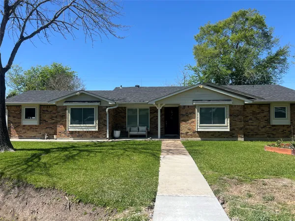 a front view of a house with a garden and trees