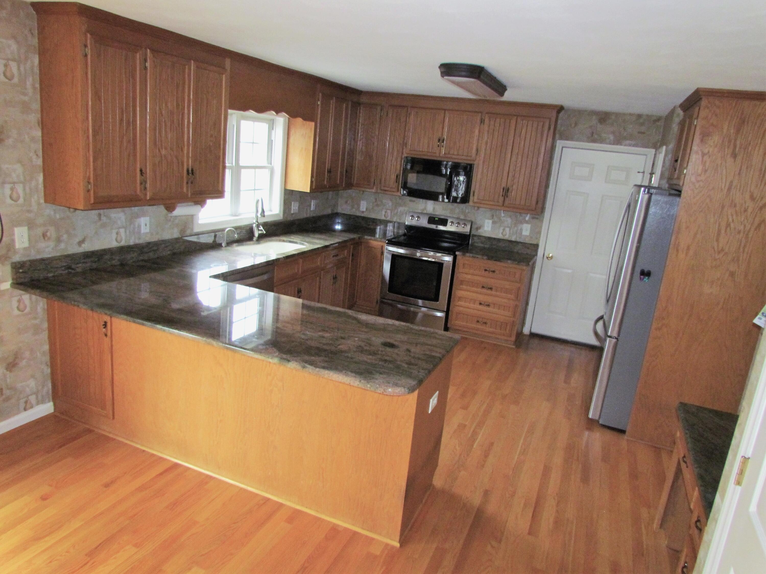 1333 Archway Road Blue Ridge, VA 24064 - Photo 14 of 37 a kitchen with granite countertop a refrigerator a sink a stove a microwave and wooden floors