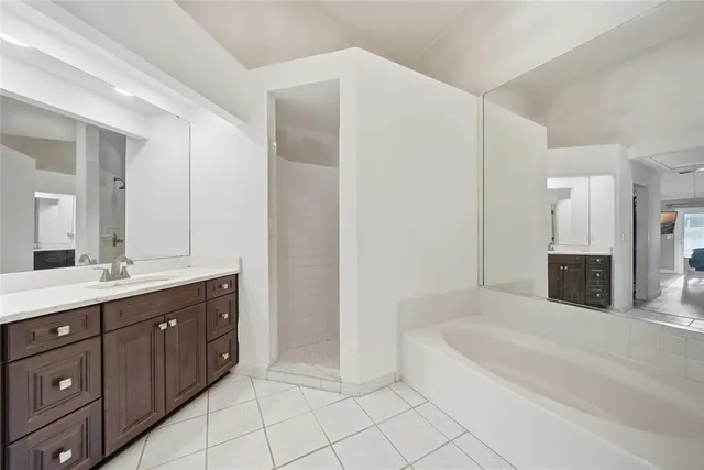 a spacious bathroom with a tub sink and mirror