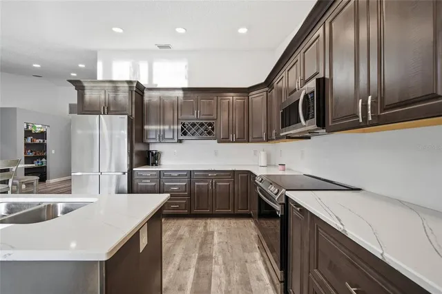 a kitchen with stainless steel appliances granite countertop a sink a stove and a refrigerator