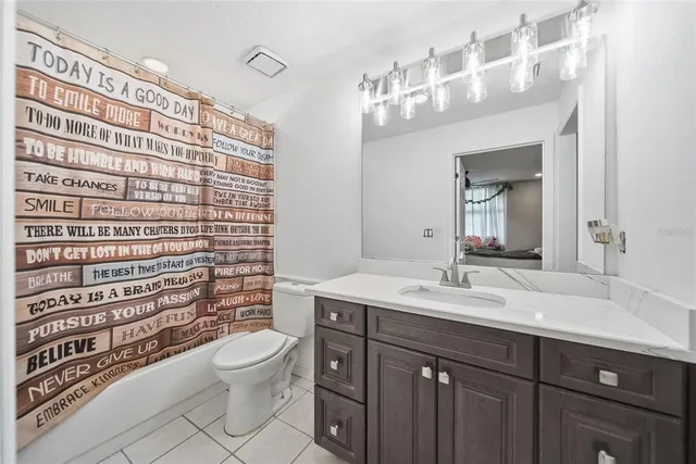 a bathroom with a sink a toilet and shower curtain