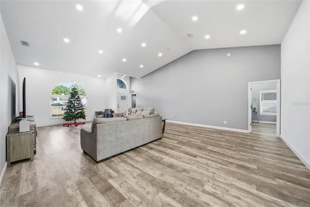 a living room with furniture and a wooden floor