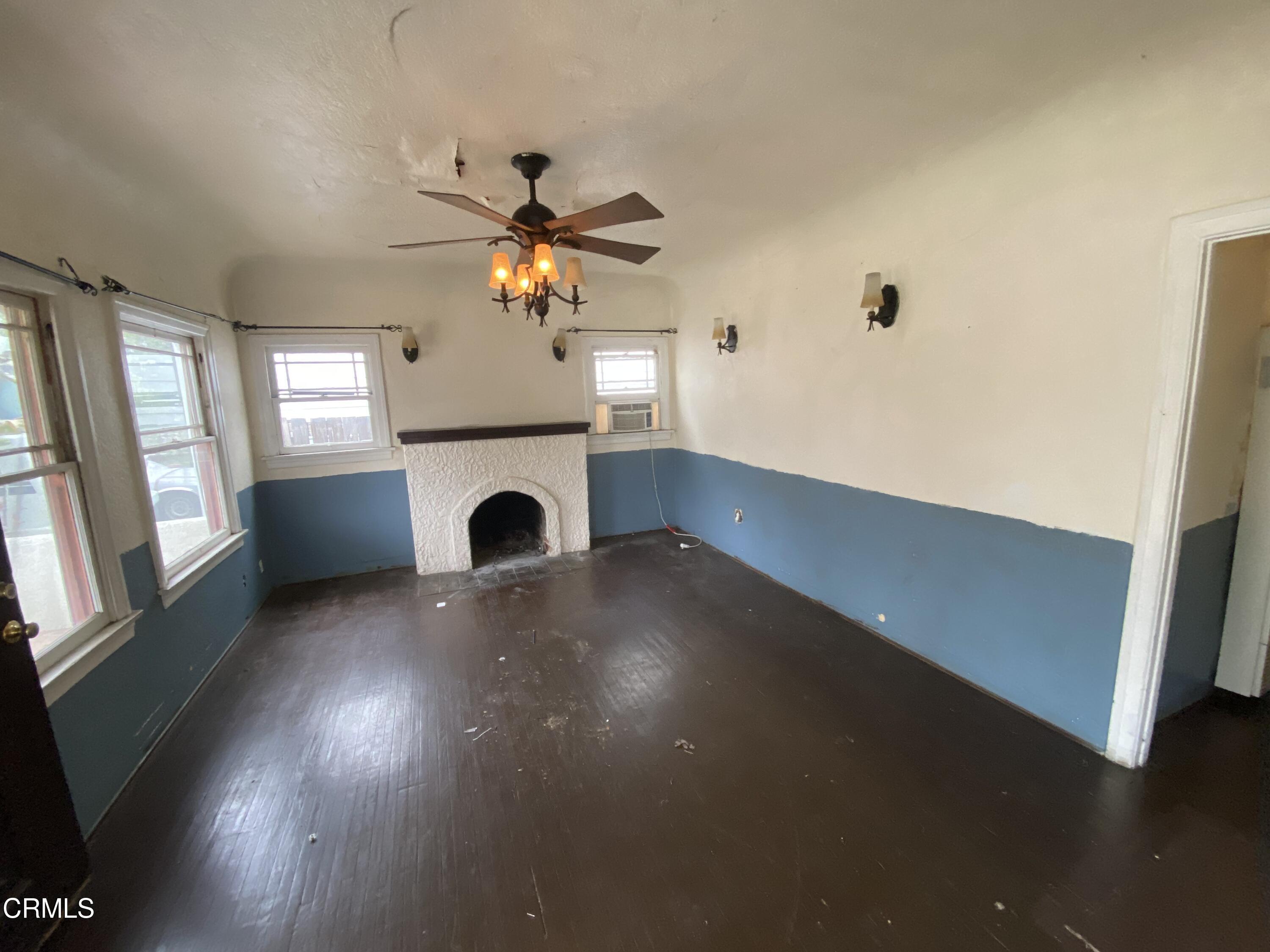 11210 Oak Street El Monte, CA 91731 - Photo 2 of 15 an empty room with windows and fireplace