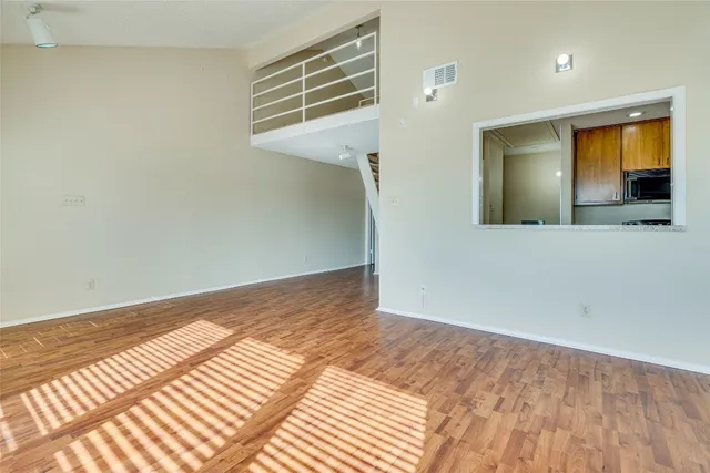 a view of a livingroom with wooden floor and a ceiling fan