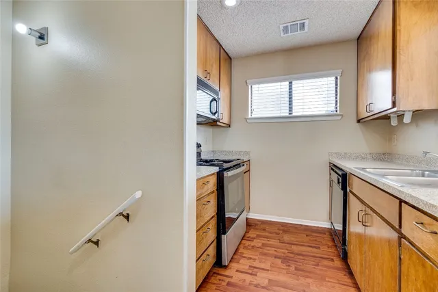 a kitchen with stainless steel appliances granite countertop a stove and a microwave