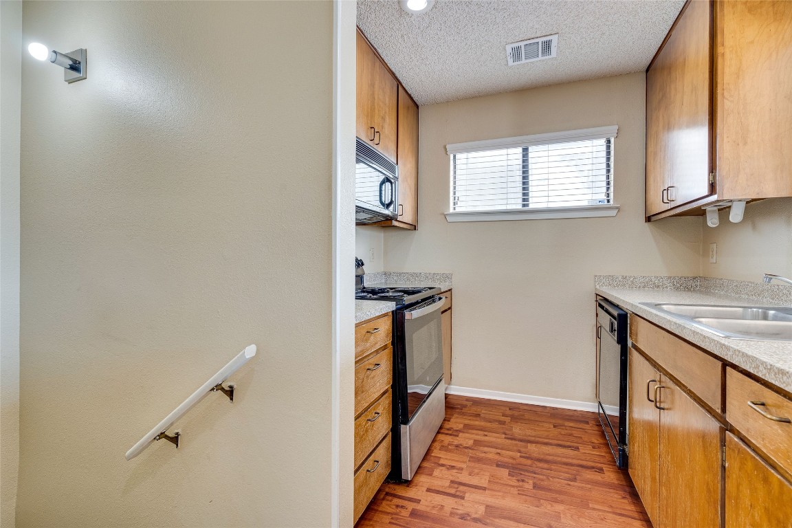 2612 San Pedro Street, Unit 222 Austin, TX 78705 - Photo 25 of 37 a kitchen with a sink a stove top oven and wooden floor