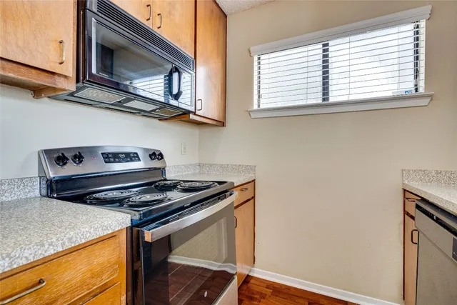 a kitchen with stainless steel appliances granite countertop a sink and a refrigerator