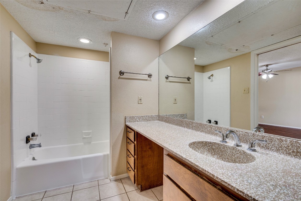 2612 San Pedro Street, Unit 222 Austin, TX 78705 - Photo 35 of 37 a bathroom with a granite countertop sink a mirror a bathtub and shower