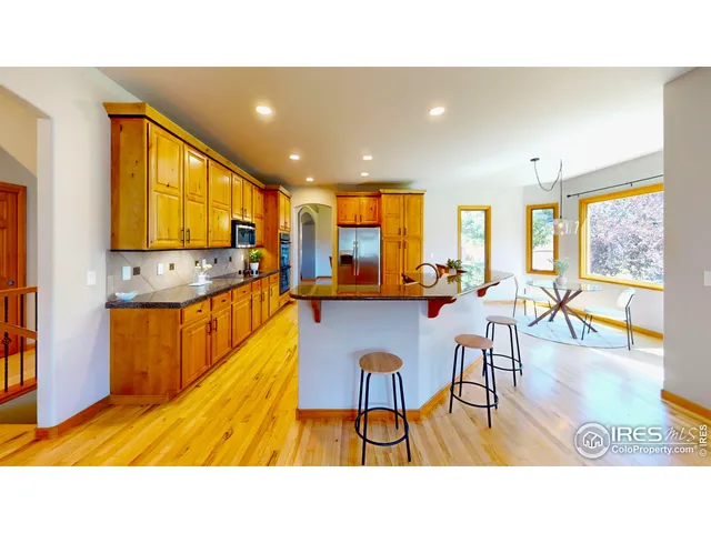 a kitchen with a table chairs refrigerator and large window