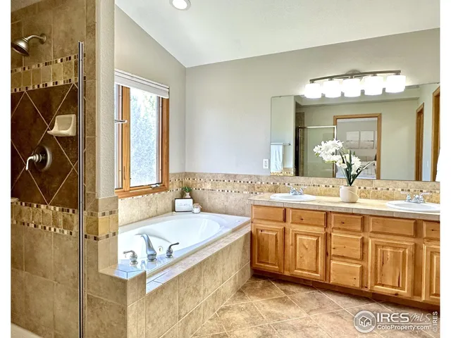 a spacious bathroom with a tub sink and mirror