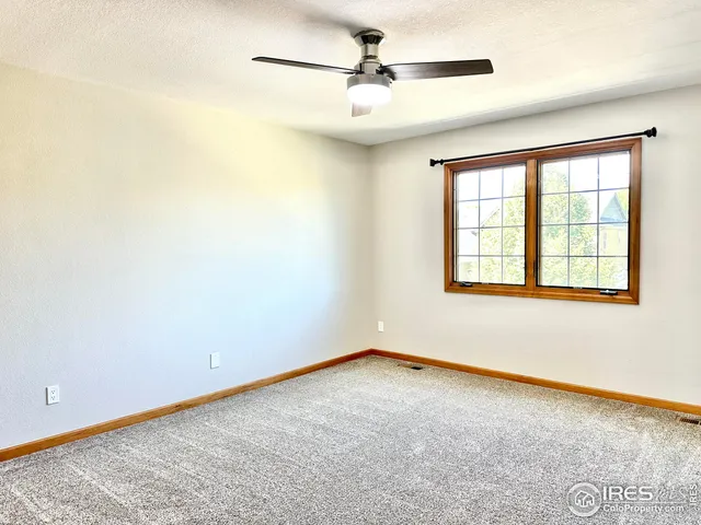 an empty room with a window and a fan