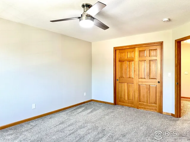 an empty room with a ceiling fan and a window