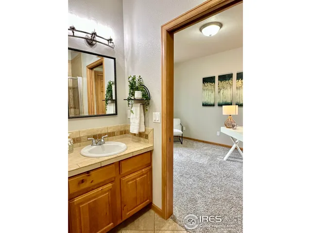 a en suite bathroom with a granite countertop sink and a mirror