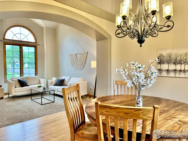 a view of a dining room with furniture a chandelier and wooden floor
