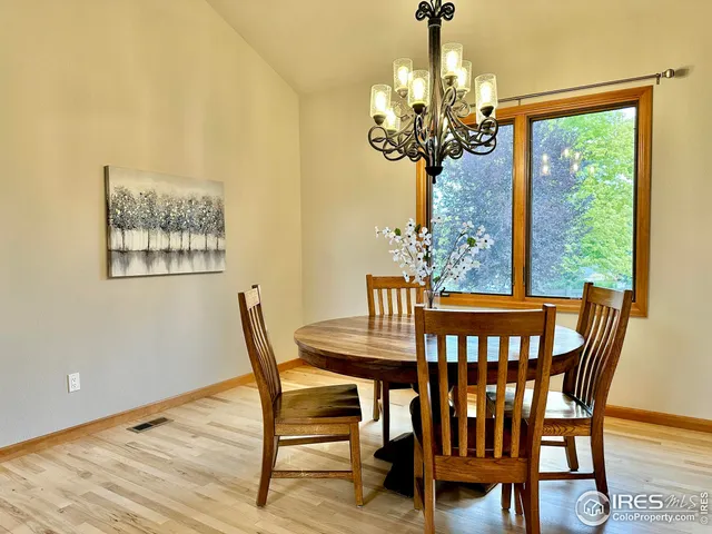 a view of a dining room with furniture a chandelier and wooden floor