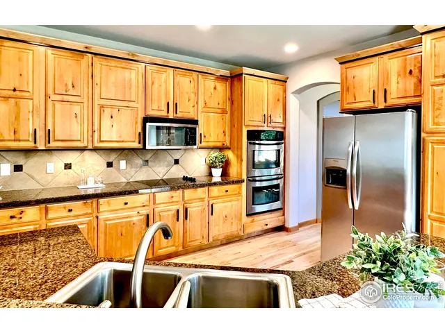 a kitchen with granite countertop a refrigerator and a sink