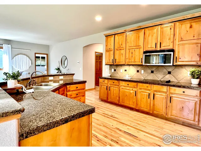 a kitchen with stainless steel appliances granite countertop a sink a stove cabinets counter space and a window