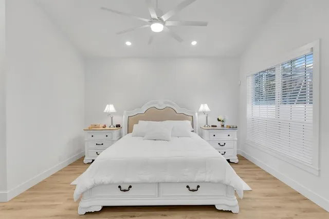 a large bed sitting in a bedroom next to a window and a chandelier