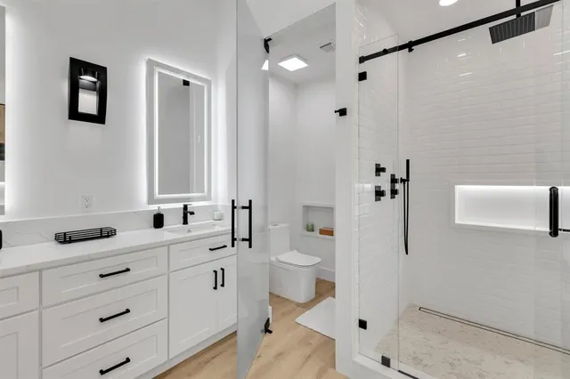 a bathroom with a double vanity sink mirror and shower