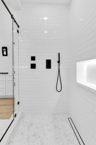 a bathroom with a granite countertop shower and a mirror