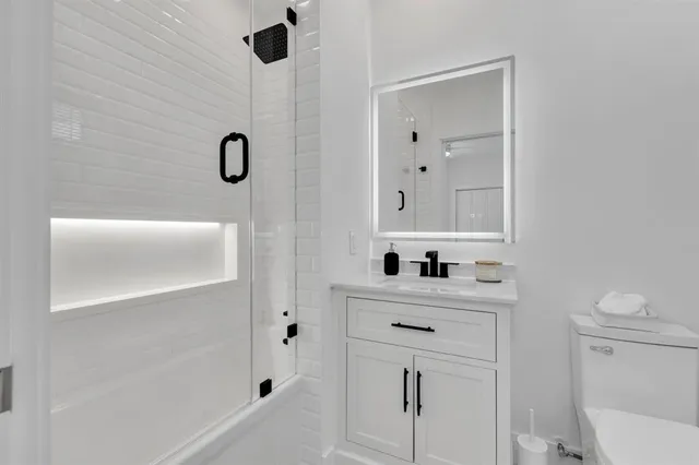 a bathroom with a sink a toilet and shower