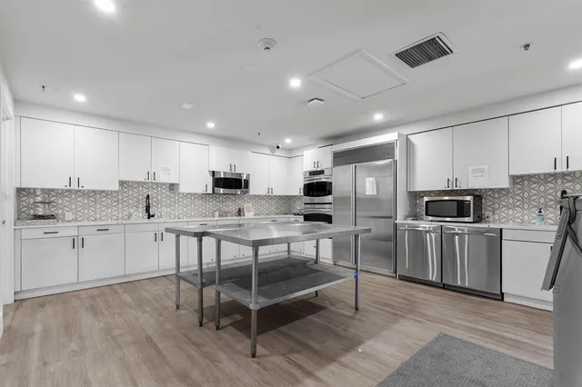 a kitchen with white cabinets and stainless steel appliances