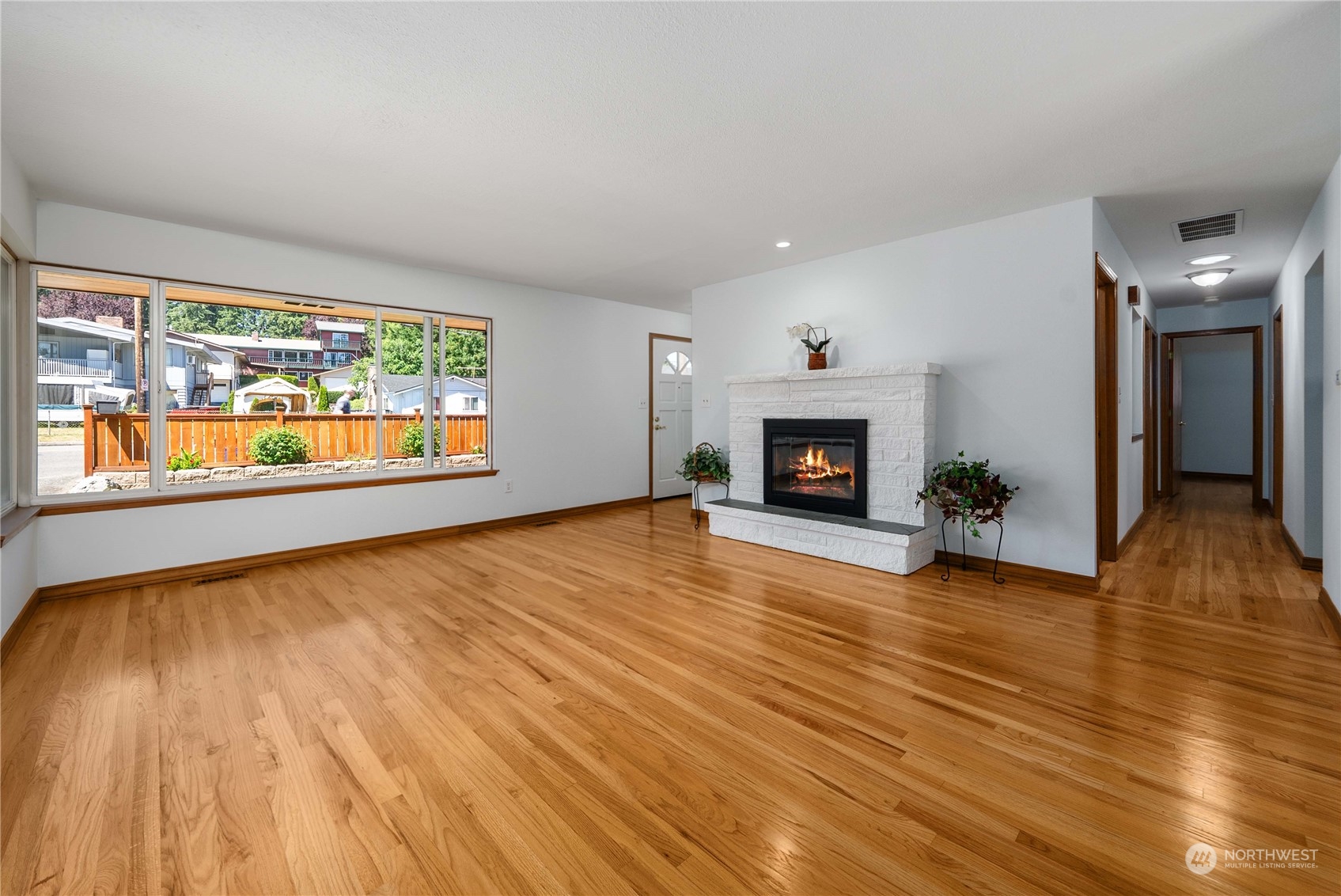 7211 Beverly Boulevard Everett, WA 98203 - Photo 5 of 36 an empty room with wooden floor fireplace and windows