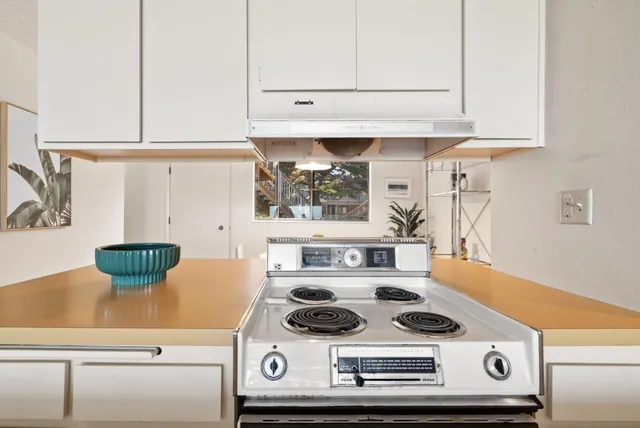 a stove top oven sitting inside of a kitchen