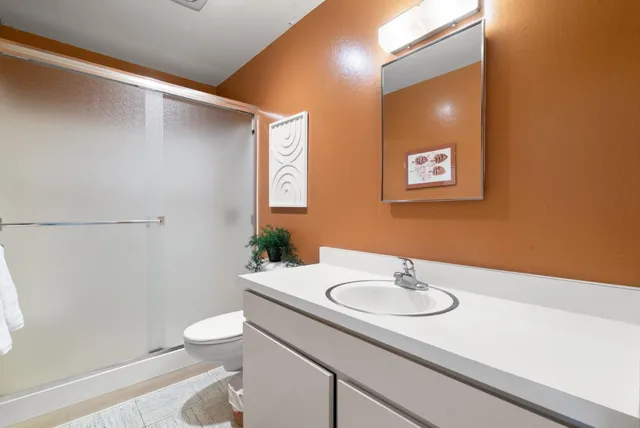 a bathroom with a sink a toilet and a mirror