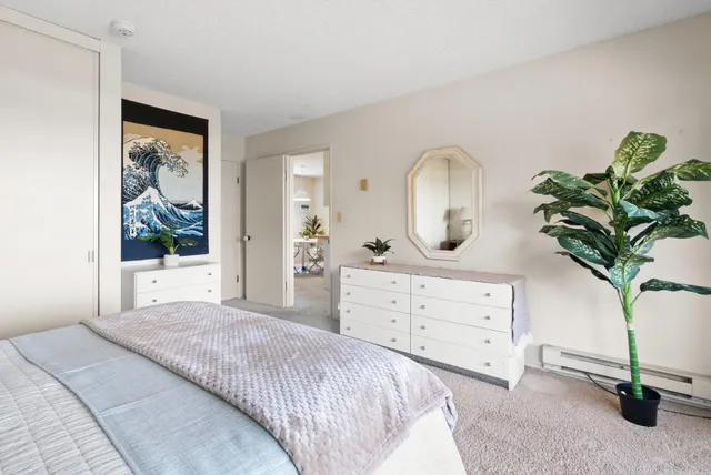 a bedroom with a bed potted plant and a window