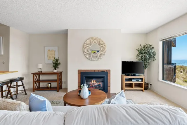 a living room with furniture a fireplace and a flat screen tv