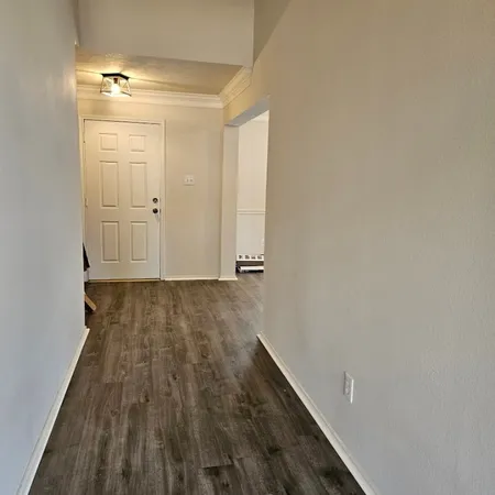 a view of a room with wooden floor and a window