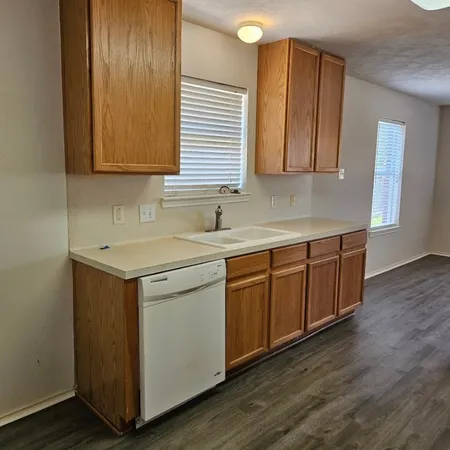 a kitchen with stainless steel appliances granite countertop a sink a stove cabinets and wooden floor